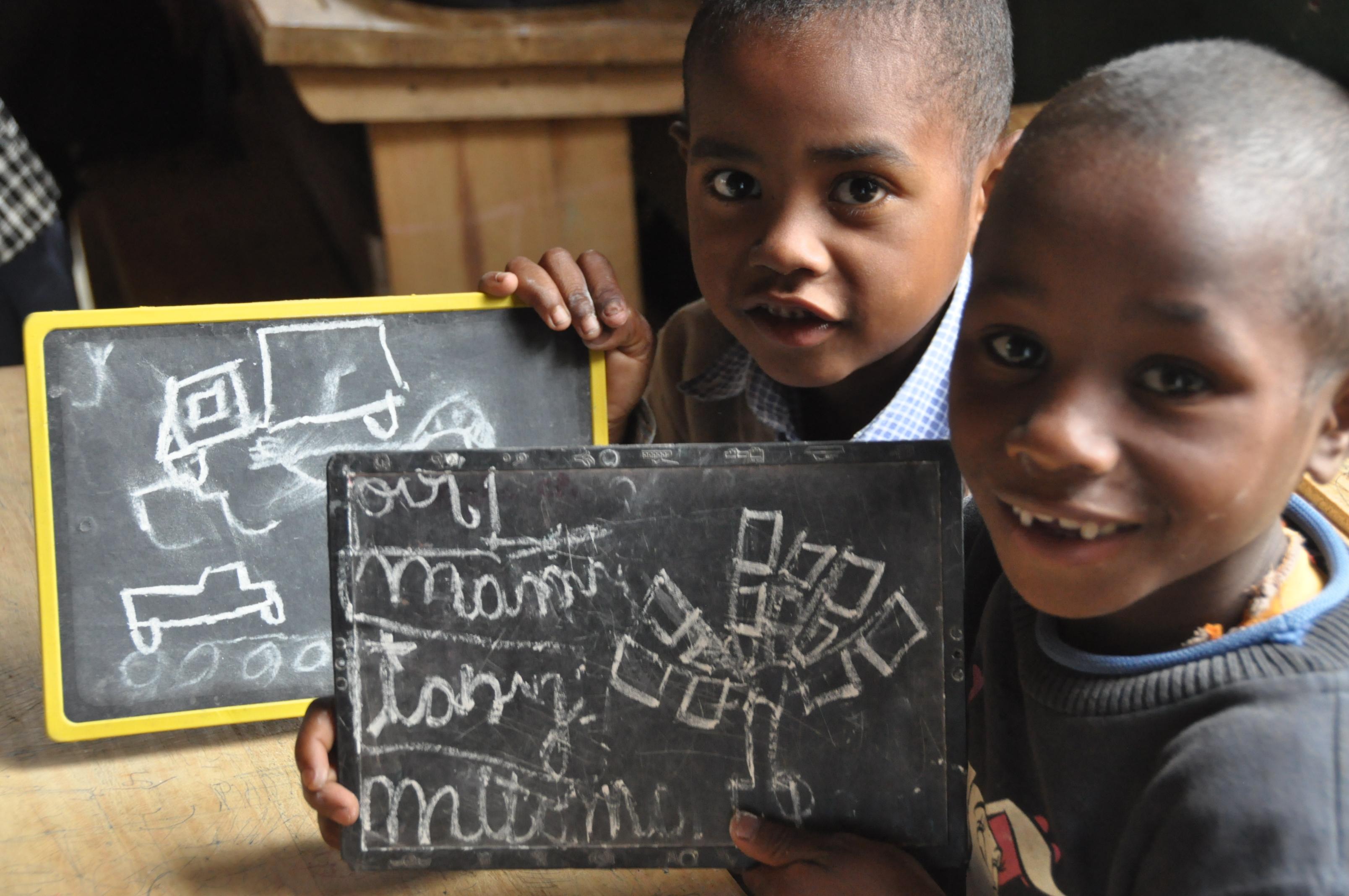 Young students show their work on mini blackboards at one of our Projects Abroad teaching placements in Madagascar Smiling students show their answers to an exercise given to them by a volunteer teaching English in Madagascar